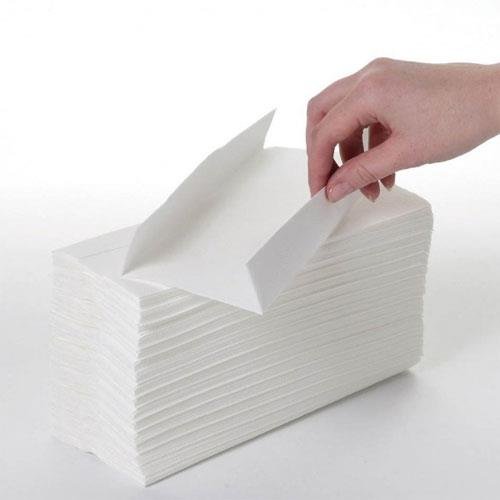Hand pulling a single M-fold towel from a stack